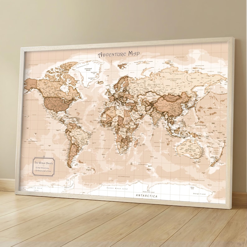 May include: A framed world map with a vintage aesthetic. The map features a sepia-toned color palette with detailed geographical information. The title "Adventure Map" is displayed at the top. The map is set against a light beige background and framed in white.