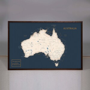 May include: A framed map of Australia with a dark blue background and white lines showing the rivers and coastlines. The map is titled "Australia" in gold lettering. The text "The Smith Family" is in the bottom left corner with a list of "Past Adventures" and "Adventures to Come" with checkboxes.