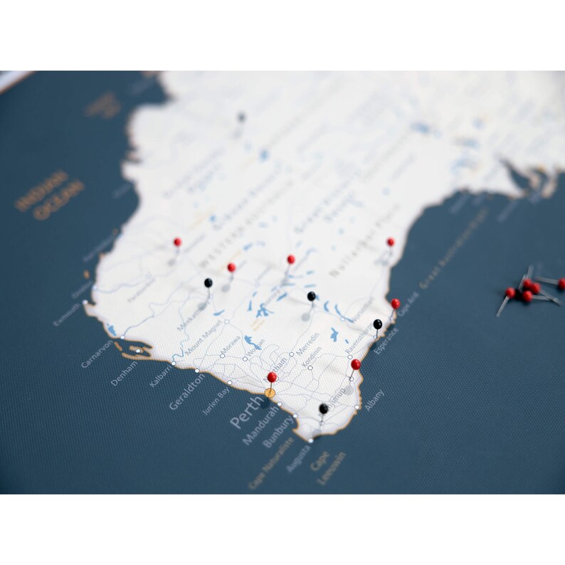 May include: A map of Western Australia with red and black push pins marking various locations. The map is printed on a white canvas and mounted on a dark blue background. The map includes the cities of Perth, Mandurah, Bunbury, Albany, and Esperance.