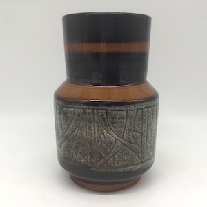 May include: A ceramic vase with a cylindrical shape, featuring a dark brown top section with a lighter brown stripe. The middle section is a lighter brown, and the bottom has a textured, gray and brown pattern. The vase is approximately 20 cm tall.