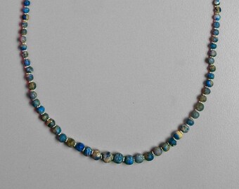 May include: A blue and green beaded necklace with a silver clasp.
