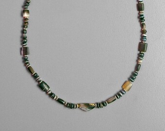 May include: A green and white agate bead necklace with a gold clasp. The necklace is made of natural stones and has a unique, earthy look.