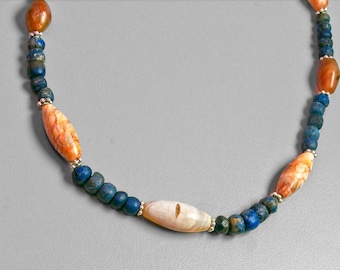 May include: A necklace made of blue and orange beads with a white shell bead in the center.
