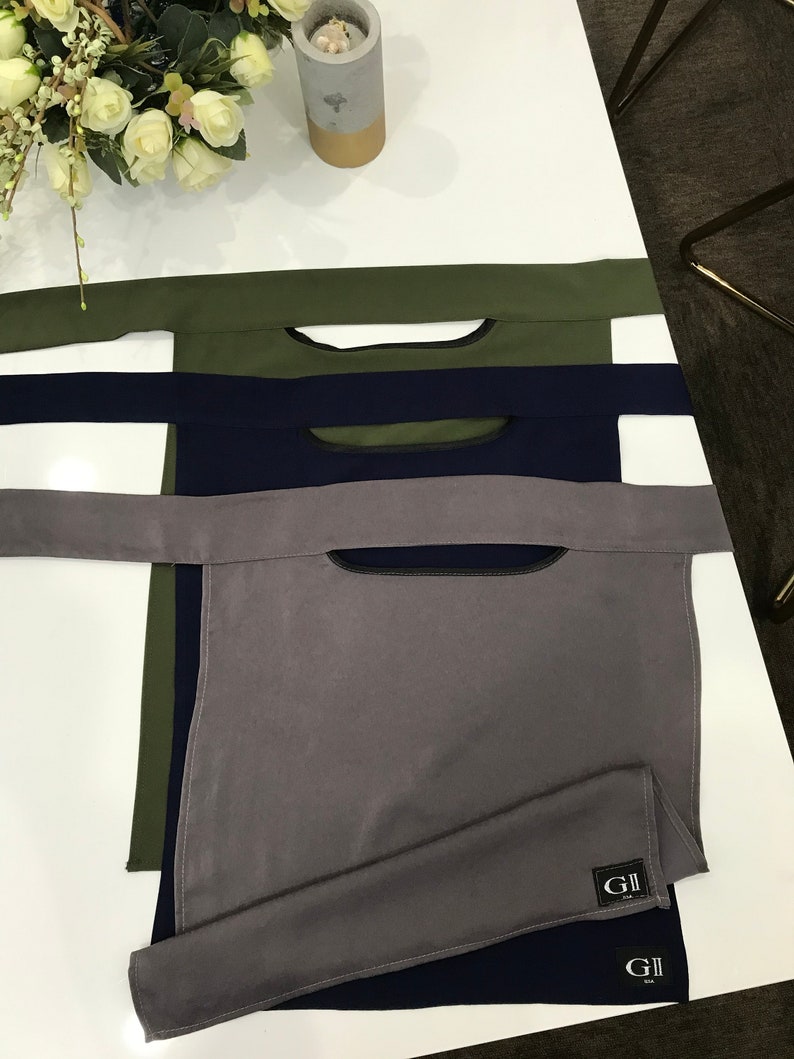 May include: Three fabric neck gaiters in different colors: olive green, navy blue, and gray. The gaiters have a small opening at the top and are labeled with the text "GII".