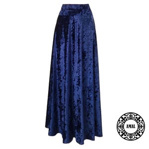 May include: A long, navy blue velvet skirt with a flowing, A-line silhouette. The skirt has a subtle crinkled texture and a high waist.