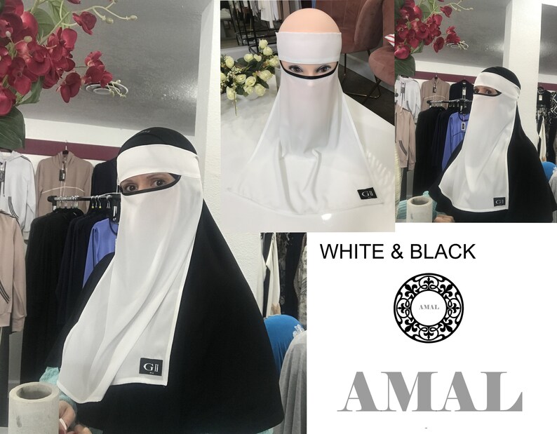 May include: White niqab with a black under-scarf. The niqab has a white face covering and a black band around the forehead. The text "GI" is visible on the niqab. The text "WHITE & BLACK" and "AMAL" are visible in the image.