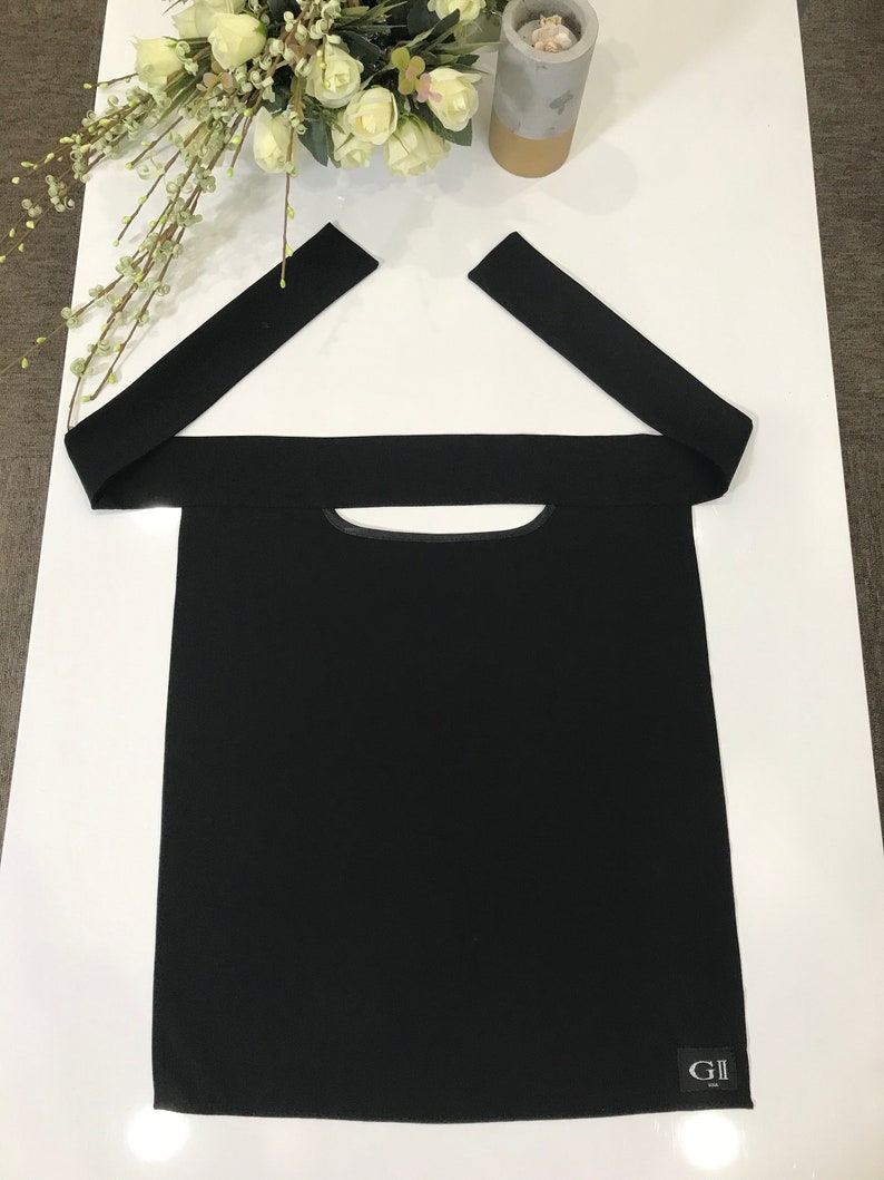 May include: Black fabric face mask with a small opening for the mouth and nose. The mask has two long straps that tie at the back of the head. The mask has a small black label with the text "GII" on it.
