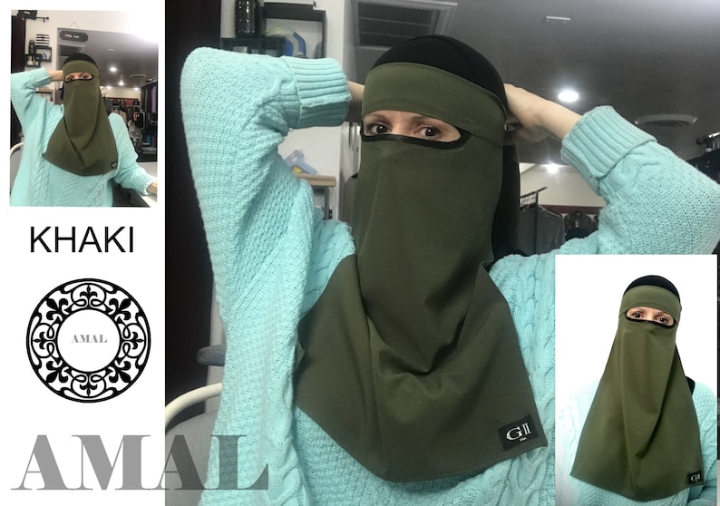 May include: A khaki green niqab with a black band around the forehead and a black eye mask. The niqab has a small black label with the text "G.II" on the bottom right corner.
