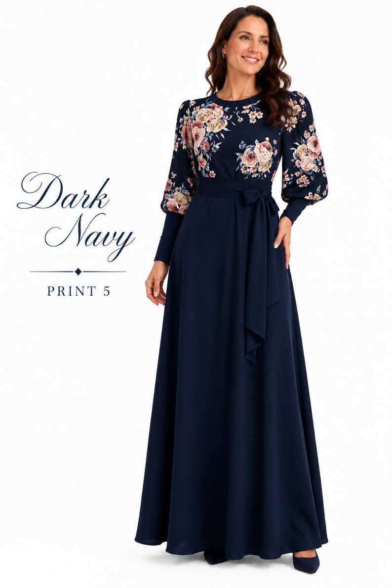 Puede incluir: Un vestido largo hasta el suelo de color azul marino oscuro con mangas largas con estampados florales en tonos rosa, crema y verde. El vestido incluye un cuello redondo, una cintura ajustada con un cintur&oacute;n de lazo a juego y una falda lisa. Texto: Dark Navy PRINT 5.