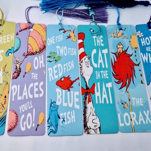 May include: A collection of six Dr. Seuss-themed bookmarks, each with a different design. The bookmarks feature illustrations and text from books like "Green Eggs and Ham" and "Horton Hears a Who!" Each bookmark has a tassel attached.