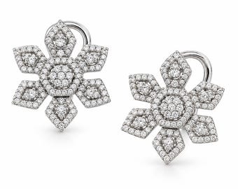 May include: A pair of silver-toned earrings shaped like six-pointed snowflakes. Each earring features a central cluster of small, clear, round-cut stones surrounded by a geometric frame entirely encrusted with tiny, sparkling white pavé stones.
