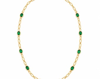 May include: A gold chain necklace featuring a series of oval-shaped, vibrant green gemstones set at regular intervals along the links. The necklace is secured with a small gold clasp at the top, showcasing a polished finish and a classic link design.