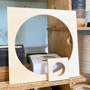 Puede incluir: Tres c&iacute;rculos de madera con recortes, el m&aacute;s grande es de madera clara con un gran recorte circular, el del medio es una pila de c&iacute;rculos de madera clara con un recorte circular m&aacute;s peque&ntilde;o, y el m&aacute;s peque&ntilde;o es un c&iacute;rculo de madera clara con un peque&ntilde;o recorte circular.