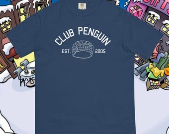 Puede incluir: Una camiseta azul marino con un gráfico blanco de un iglú y el texto "Club Penguin Est. 2005".