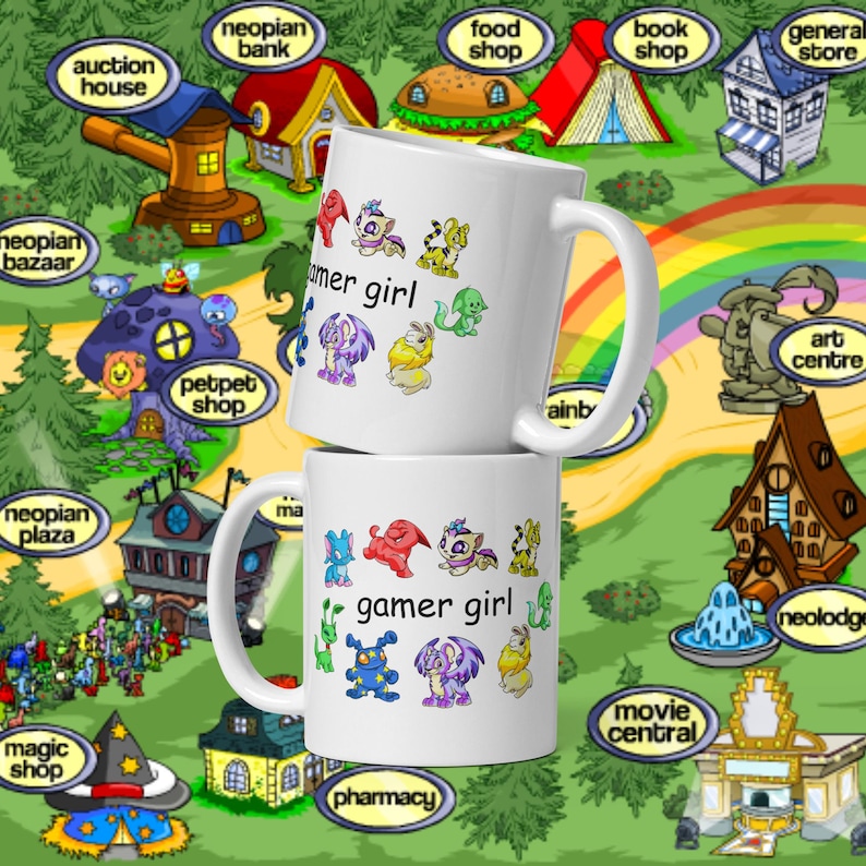 Peut inclure: Deux mugs en c&eacute;ramique blanche superpos&eacute;s. Chaque mug porte l'inscription "gamer girl" avec des cr&eacute;atures de dessins anim&eacute;s color&eacute;es. L'arri&egrave;re-plan est une carte avec des boutiques et des b&acirc;timents.