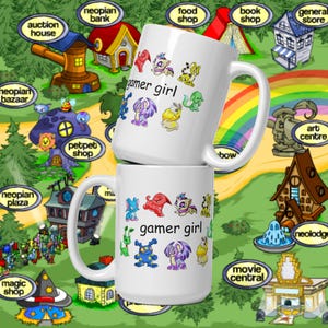 Peut inclure: Deux mugs en c&eacute;ramique blanche avec l'inscription "gamer girl" et des cr&eacute;atures de dessins anim&eacute;s color&eacute;es. Les mugs sont plac&eacute;s sur un fond fantaisiste avec un arc-en-ciel et des b&acirc;timents.