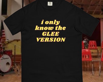 Op de afbeelding: Zwart T-shirt met de tekst "i only know the GLEE VERSION" in geel met een rode omtrek.