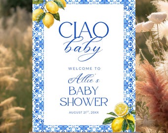 May include: A baby shower welcome sign on an easel. The sign has a white background with a blue and white decorative border. The text "CIAO baby" is in elegant blue script. The sign also includes the text "Welcome to Allie's Baby Shower". Lemons are in the corners.