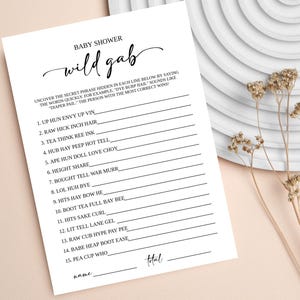 May include: A printable baby shower game with the title "wild gab". The game instructs players to uncover the secret phrase hidden in each line by saying the words quickly. For example, "dye burp hail" sounds like "diaper fail". The person with the most correct answers wins.