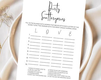May include: A white card with the text "Dirty Scattergories" in a script font. The card includes fill-in-the-blank prompts for a wedding game, with categories like "Songs to make love to" and "Something that turns you on."