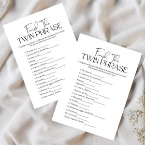 May include: Two white paper sheets with the text "Finish The Twin Phrase" in elegant script. The sheets contain fill-in-the-blank questions, designed as a game. The text is in black, and the background is a soft, neutral color.