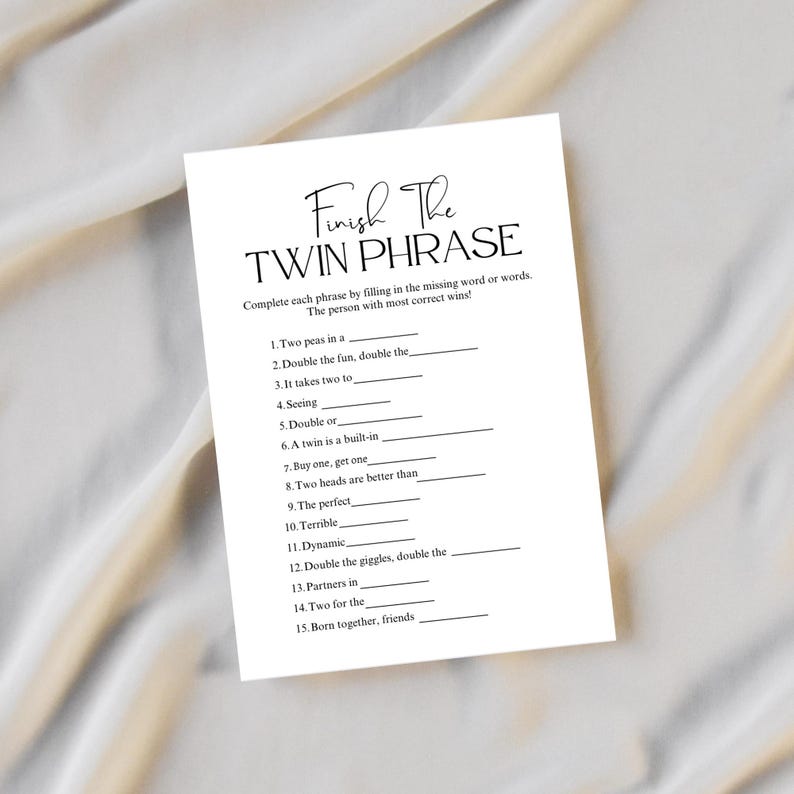 May include: A white card with the text "Finish The Twin Phrase" in a script font. The card has fill-in-the-blank phrases such as "Two peas in a" and "Double the fun, double the". The card is designed for a game.