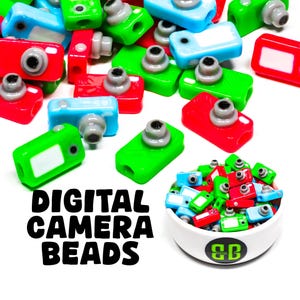 May include: A bowl filled with colorful plastic camera beads. The beads are red, green, blue, and gray. The bowl is white with a black "CB" logo. The text "DIGITAL CAMERA BEADS" is written in black letters on a white background.