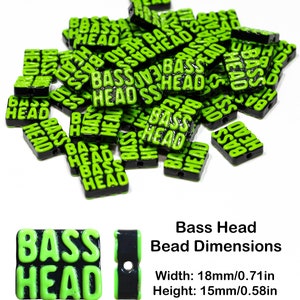 May include: A pile of green and black plastic beads with the words "Bass Head" printed on them. The beads are 18mm wide, 15mm high, and have a 2mm hole.