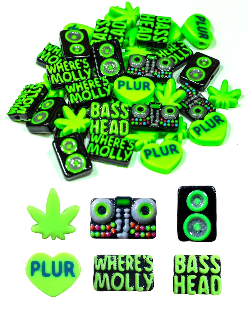 May include: A collection of green and black resin charms with various designs, including a heart with the word "PLUR", a marijuana leaf, a speaker, a boombox, and a rectangle with the text "Where's Molly".