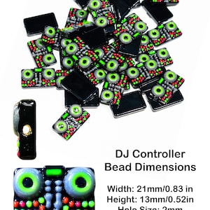 May include: A pile of black and green DJ controller-shaped beads with a single bead in the foreground. The beads are approximately 0.83 inches wide and 0.52 inches tall. The beads have a hole in the center for stringing. The text "DJ Controller Bead Dimensions" is below the beads. The text "Width: 21mm/0.83 in" is below the text "DJ Controller Bead Dimensions". The text "Height: 13mm/0.52in" is below the text "Width: 21mm/0.83 in". The text "Hole Size: 2mm" is below the text "Height: 13mm/0.52in".