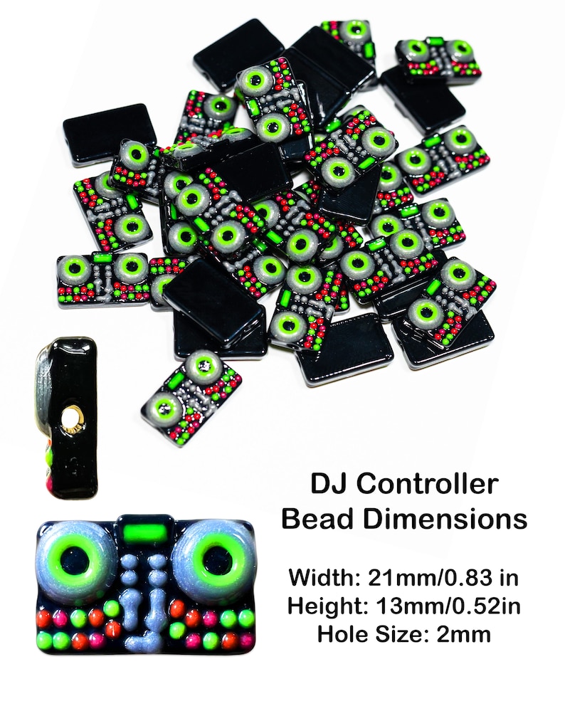 May include: A pile of black and green DJ controller-shaped beads with a single bead in the foreground. The beads are approximately 0.83 inches wide and 0.52 inches tall. The beads have a hole in the center for stringing. The text "DJ Controller Bead Dimensions" is below the beads. The text "Width: 21mm/0.83 in" is below the text "DJ Controller Bead Dimensions". The text "Height: 13mm/0.52in" is below the text "Width: 21mm/0.83 in". The text "Hole Size: 2mm" is below the text "Height: 13mm/0.52in".