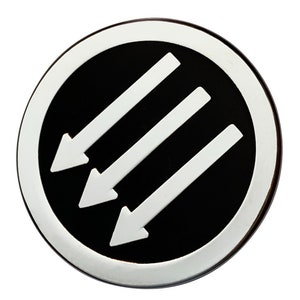 May include: A black and white circle with three white arrows pointing to the left inside. The circle has a silver border.
