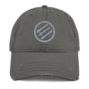 May include: Distressed gray baseball cap featuring a light blue circular emblem with three downward-pointing arrows. The cap has a pre-worn look with distressed edges and a curved brim. A stylish accessory for casual wear.