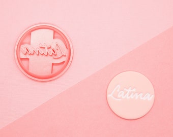 May include: Two pink round stickers with the word "Latina" written in white cursive lettering.