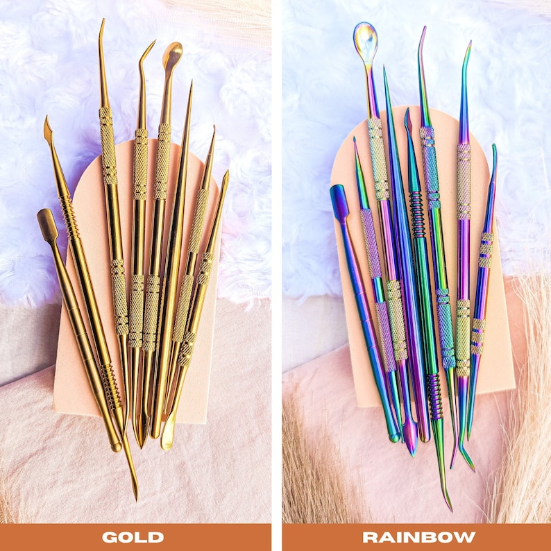 May include: Two sets of nail art tools, one set is gold and the other is rainbow. The tools are arranged on a light pink surface.