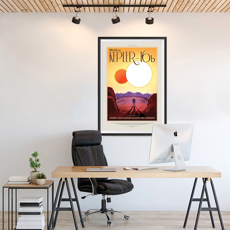 Puede incluir: Un p&oacute;ster enmarcado con un dise&ntilde;o de p&oacute;ster de viaje retro. El p&oacute;ster presenta una puesta de sol roja y naranja con dos estrellas en el cielo. El texto en el p&oacute;ster dice "Relax on Kepler-16b, where your shadow always has company."