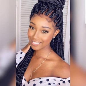 May include: A black braided wig with a high ponytail. The wig is styled in a box braid pattern and is worn by a person with dark skin. The person is wearing a white polka dot shirt.