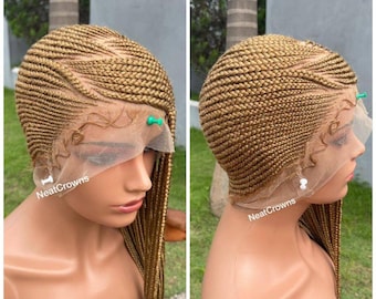 May include: A blonde braided wig with a lace front and a side part. The wig is styled in a neat, intricate pattern. The wig is on a mannequin head and is being held in place with pins. The text "NeatCrowns" is visible on the wig.