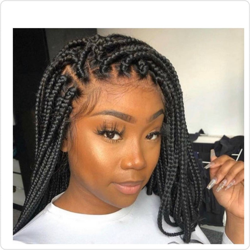 May include: A black braided wig with a lace front. The wig is styled in a short bob with the braids going straight down.