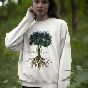 Puede incluir: Sudadera blanca con un dise&ntilde;o de &aacute;rbol de acuarela y las palabras "biophilia spirit" impresas en la parte delantera.