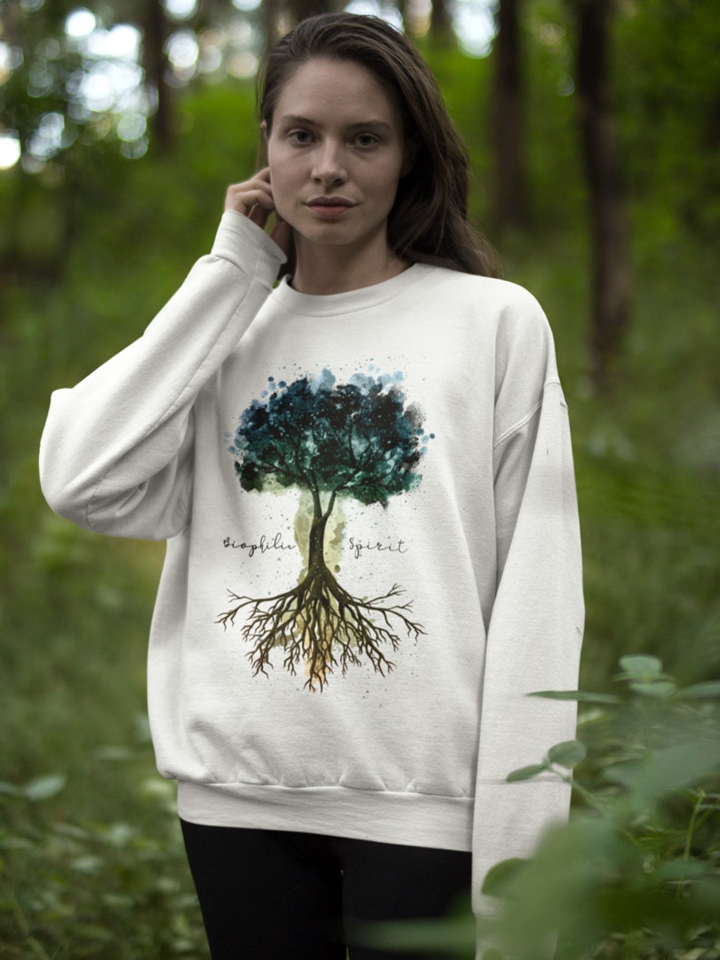 Puede incluir: Sudadera blanca con un dise&ntilde;o de &aacute;rbol de acuarela y las palabras "biophilia spirit" impresas en la parte delantera.