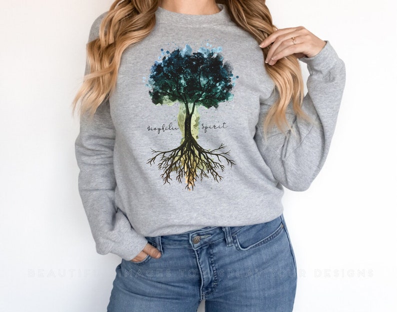 Puede incluir: Sudadera gris con un dise&ntilde;o de &aacute;rbol de acuarela. El &aacute;rbol tiene hojas verdes, azules y amarillas. Las ra&iacute;ces del &aacute;rbol est&aacute;n etiquetadas como "fr&aacute;gil" y "esp&iacute;ritu".