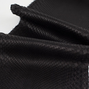 Può includere: Pelle di serpente nera con una superficie testurizzata.