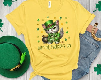 May include: A yellow t-shirt featuring a cartoon cat dressed as a leprechaun, wearing a green hat and holding a pot of gold. The text "Happy St. Pawtrick's Day" is printed on the shirt.