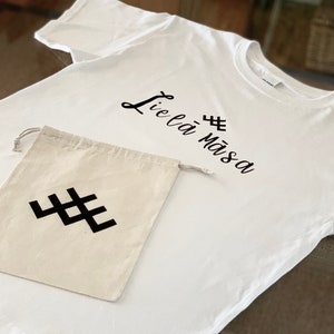 May include: White t-shirt with black text that says "Lie là mà sa" and a black symbol. A white drawstring bag with a black symbol.