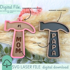 Könnte beinhalten: Zwei Holzhammer-Ornamente, eines rosa und eines schwarz, mit den Wörtern "MOM" und "PAPA" darauf graviert. Die Ornamente befinden sich auf einem hellbraunen Hintergrund. Der Text "#1" ist auf dem rosa Ornament sichtbar. Der Text "CUT FONT" und "ENGRAVED FONT" ist auf dem Bild sichtbar. Der Text "SVG LASER FILE digital download" ist am unteren Rand des Bildes sichtbar.