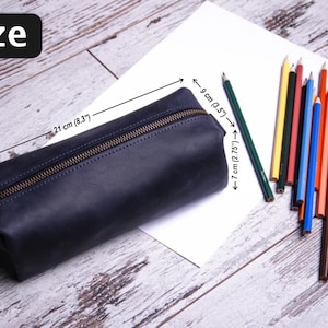 Peut inclure: Une trousse &agrave; crayons en cuir bleu fonc&eacute; avec une fermeture &agrave; glissi&egrave;re. La trousse mesure 21 cm de long, 9 cm de large et 7 cm de haut.