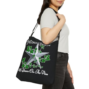 May include: Black tote bag with a white five-pointed star surrounded by green ivy. The text "Silver Star" and "25 Years On The Vine" are printed on the bag.
