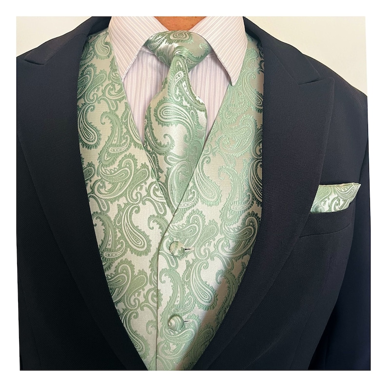 May include: A green paisley patterned vest with a matching tie and pocket square. The vest has a white background with green paisley patterns.