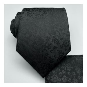 May include: A black silk tie with a subtle floral pattern.